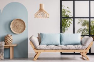 A white futon mattress on a wooden frame in a room with a window.