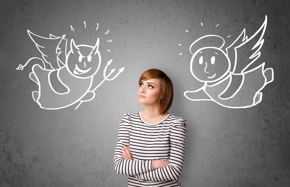 Young woman standing between the angel and the devil drawings ; no rest for the wicked concept.