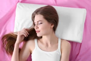 Young woman sleeping on orthopedic pillow. Healthy posture concept