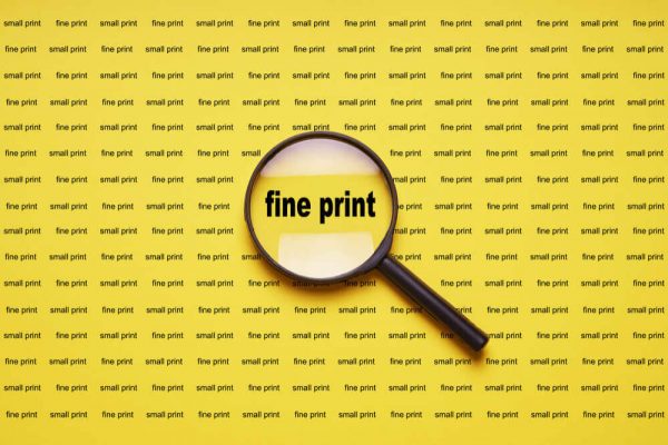 fine-print fine print enlarged with magnifying glass magnifier loupe, buying a mattress online concept.
